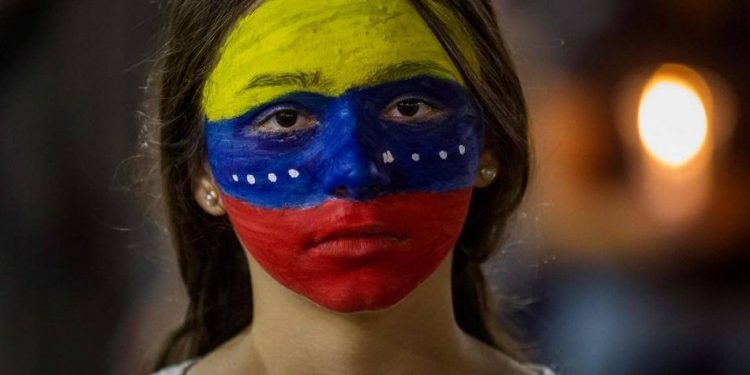 Efemérides Venezuela. Mujer venezolana con los colores de la bandera pintados en su cara, durante una vigilia de protesta en Caracas el 29 de abril de 2017 (Foto: El Nuevo Herad/EFE). Entre 2014 y 2017 Venezuela fue centro de protestas generalizadas contra la dictadura madurista y su destrucción sistemática de la economía venezolana. Efemérides Venezuela. Mujer venezolana con los colores de la bandera pintados en su cara, durante una vigilia de protesta en Caracas el 29 de abril de 2017 (Foto: El Nuevo Herad/EFE). Entre 2014 y 2017 Venezuela fue centro de protestas generalizadas contra la dictadura madurista y su destrucción sistemática de la economía venezolana.